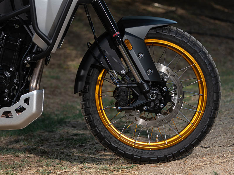Primer plano de la rueda delantera de rayos con llanta dorada, neumático Pirelli Scorpion y horquilla invertida Kayaba de la Kove 625X